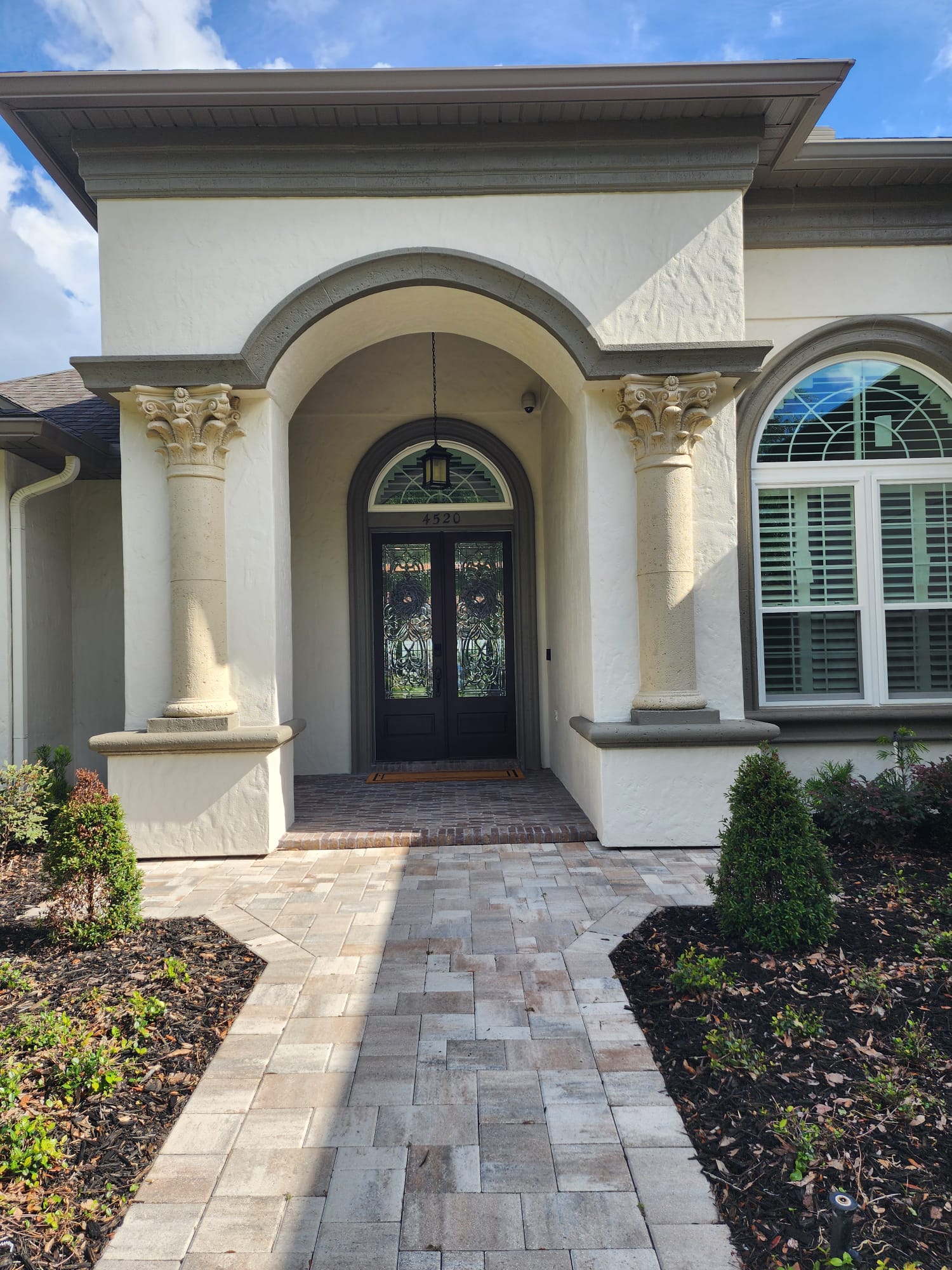 Home entrance with Corinthian foam columns and arched doorway